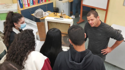 Students being introduced by a beekeeper on how a beehive works